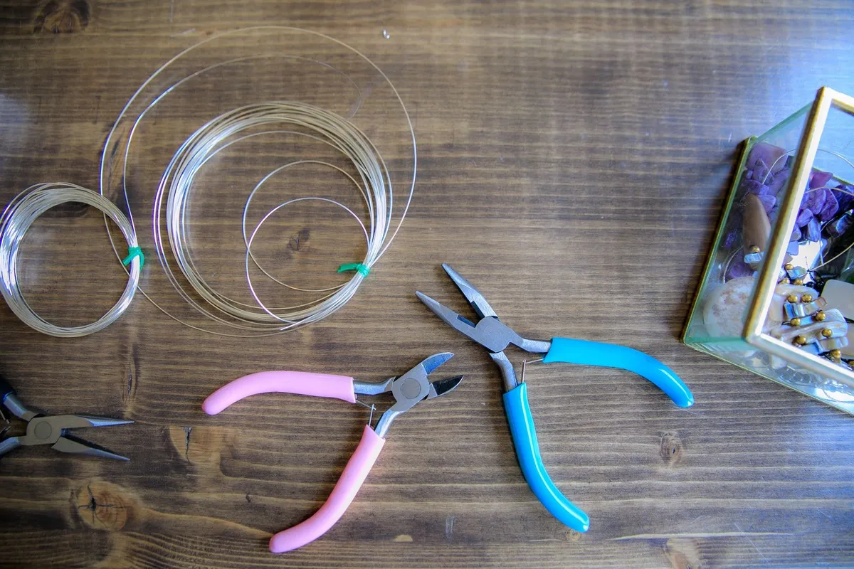 Crafting tools and wires on a wooden surface, reflecting the precision in creating luxury watches.
