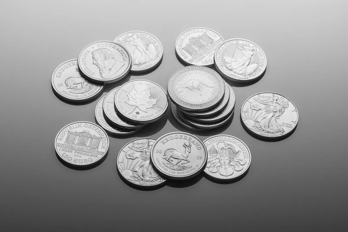 Close-up of shiny silver bullion coins with detailed designs, relevant to selling precious metals.