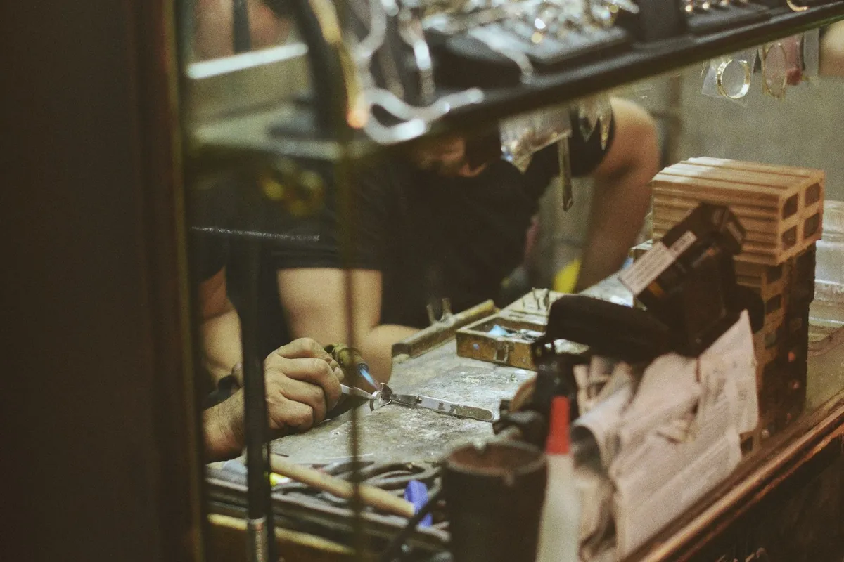 An artisan meticulously crafting a luxury watch in a jewelry workshop, highlighting expert craftsmanship.