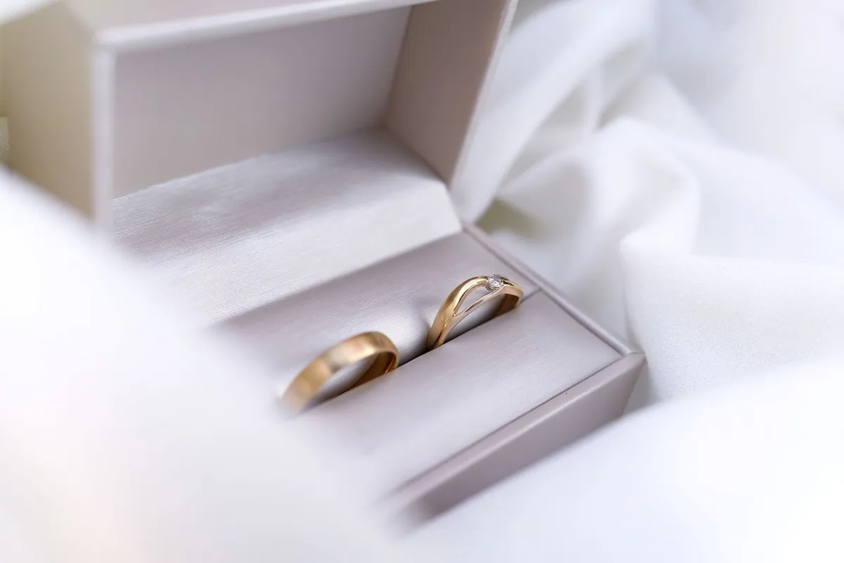 Close-up of gold wedding rings nestled in a velvet box, symbolizing changing relationships and stories.