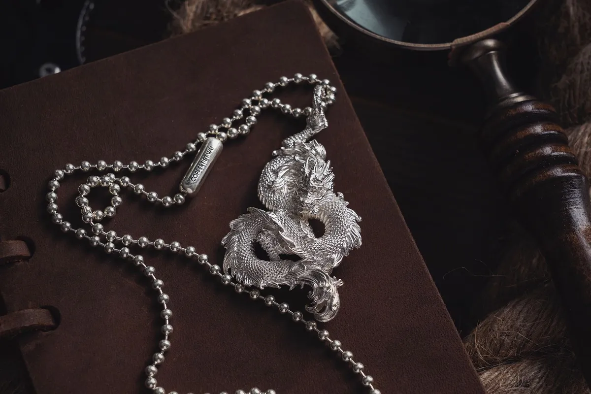 Elegant silver dragon pendant necklace on dark leather, highlighting intricate craftsmanship related to silver value.